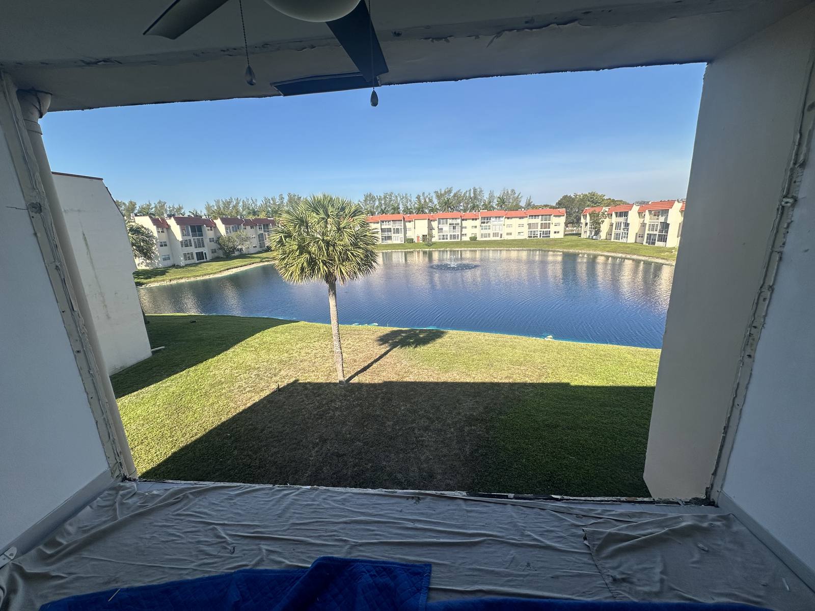 Window opening after old window removal, floor protected with a drop cloth, South Florida home