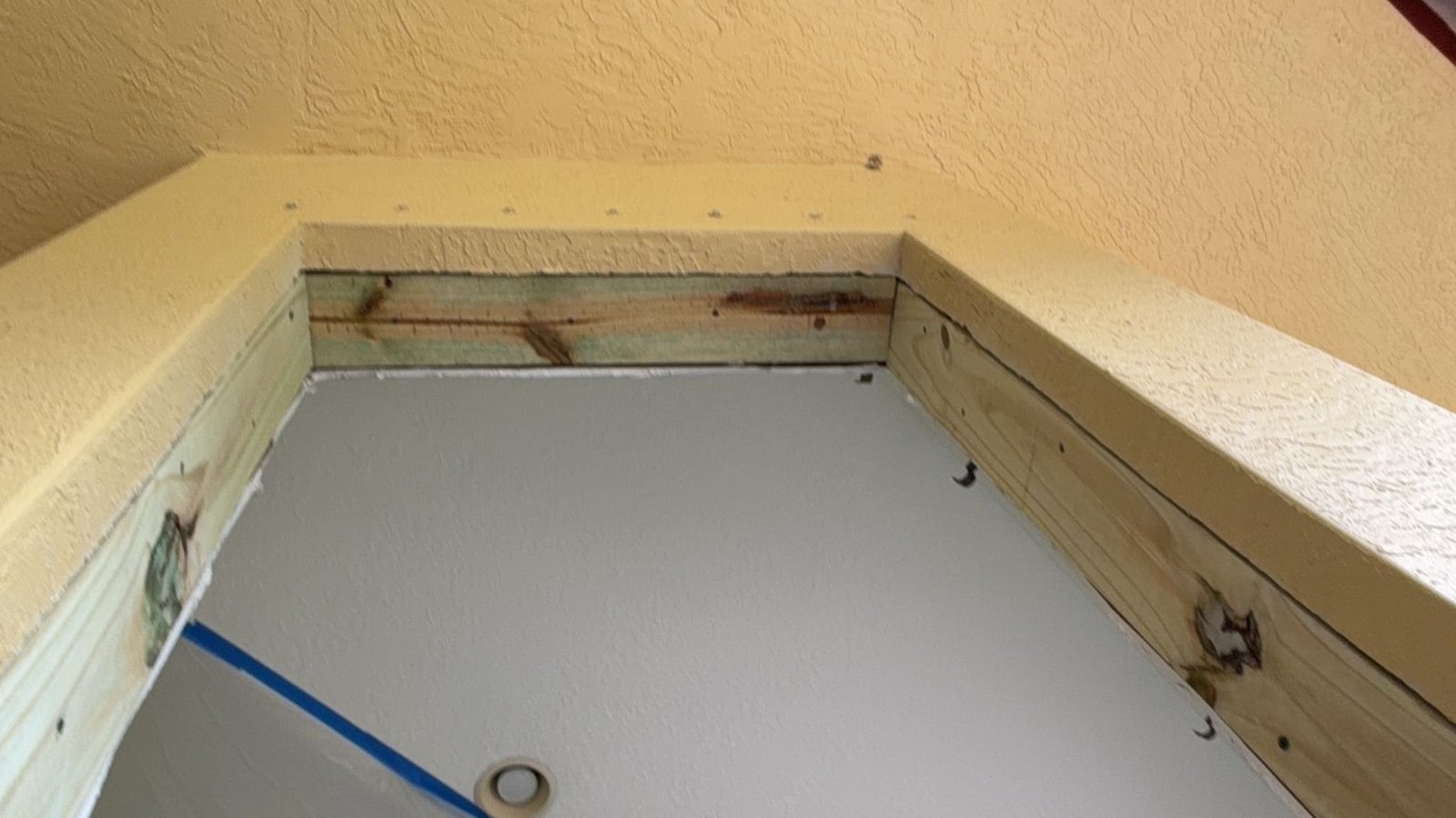 Wood buck anchored around a window opening before impact window installation
