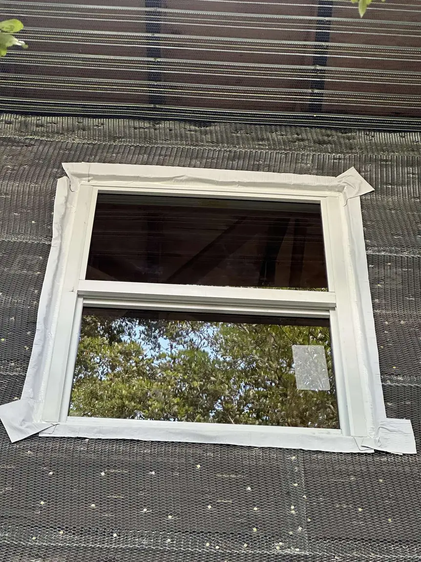 White impact window with flashing tape around the frame during new construction