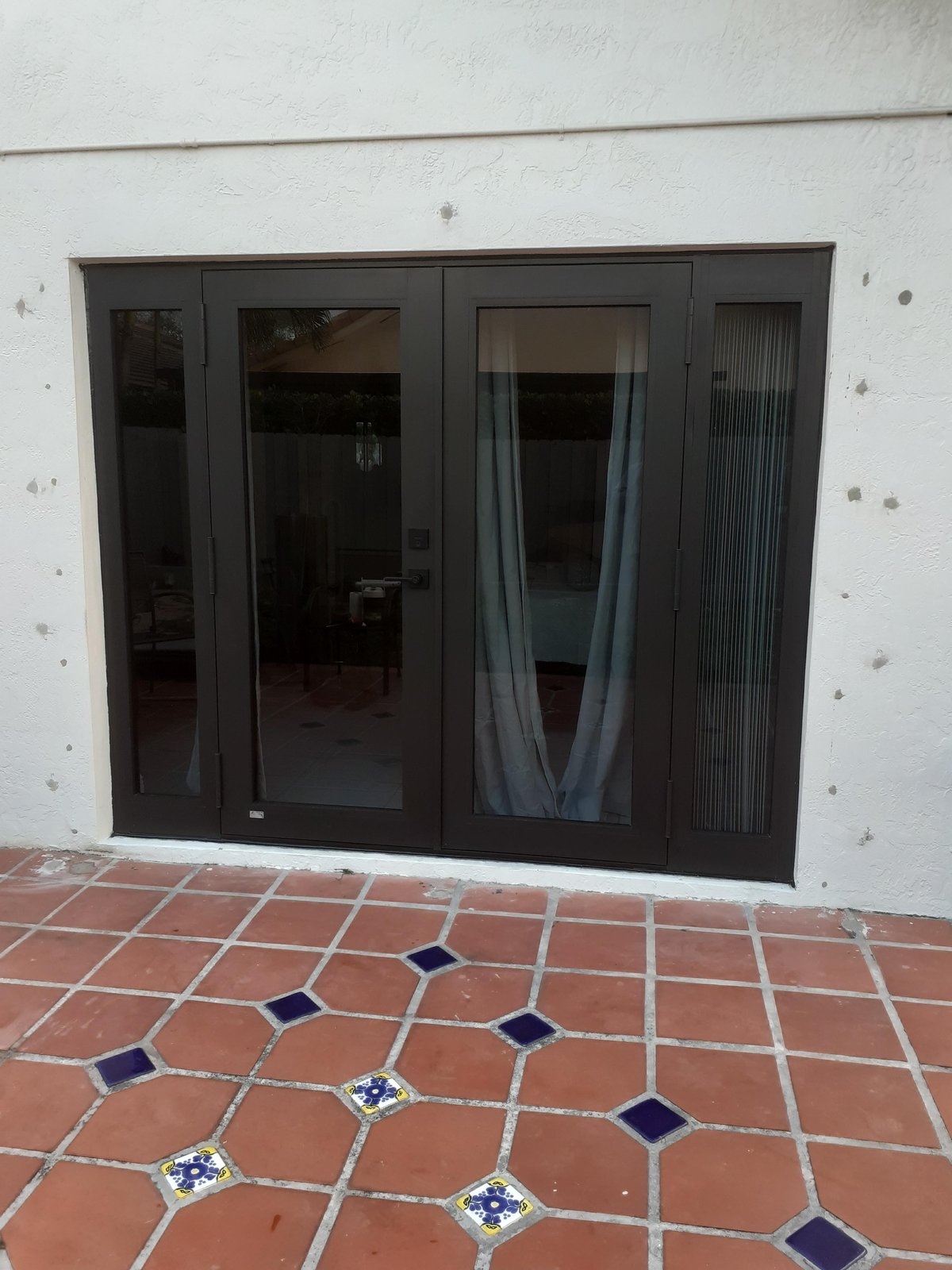 Bronze French door with sidelites installed on a tiled patio