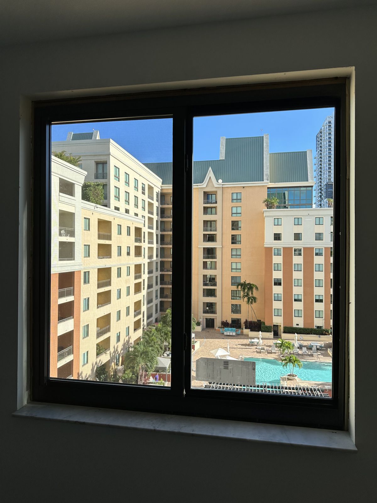 Black horizontal rolling impact window in a high-rise condo with a city view
