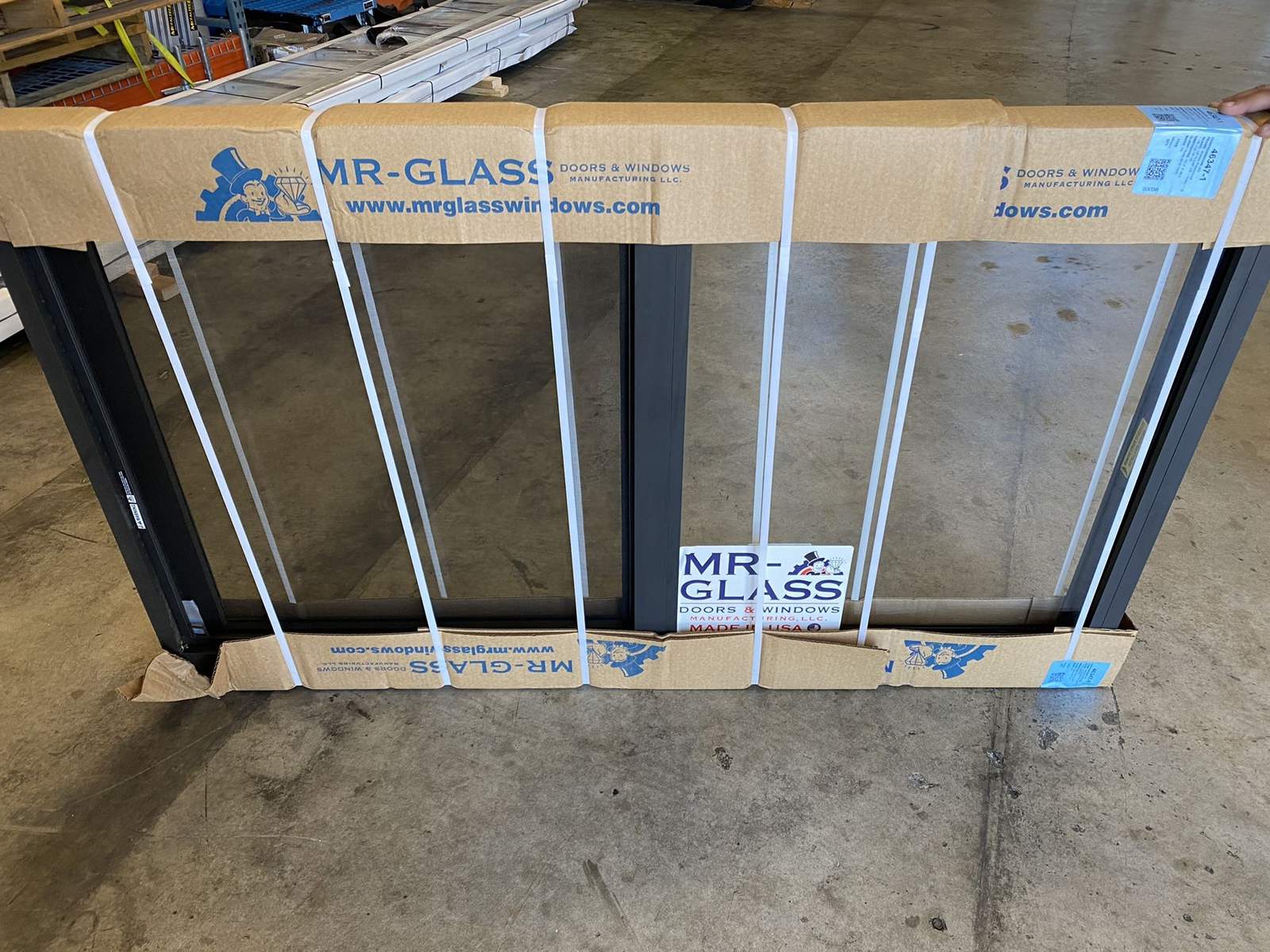 Mr. Glass impact window unit in factory packaging on a warehouse floor